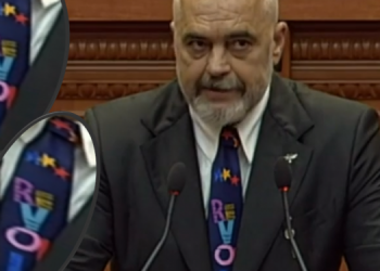 Blu me yje/ Rama me kollare ku shkruhej në gërma të qendisura fjala “Revolution”